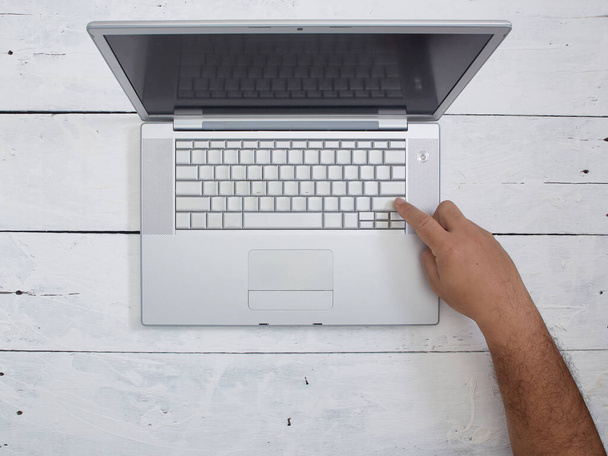 Düz adam dizüstü bilgisayarı beyaz ahşap doku arka planında kullanıyor. Ev kavramından çalış. metin için boşluk kopyala - Fotoğraf, Görsel