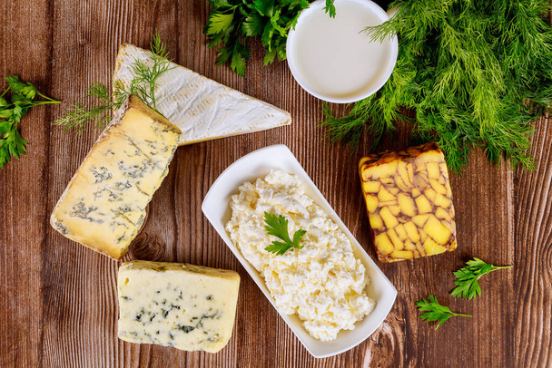 Diferentes tipos de productos lácteos, queso, leche y requesón sobre fondo de madera. fiesta judía shavuot
. - Foto, imagen