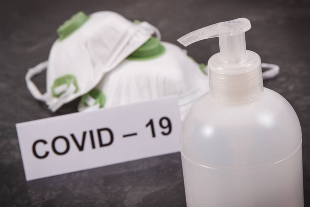 Disinfectant liquid with alcohol in bottle and protective mask N95. Disinfection hands and stop spreading outbreak coronavirus. Covid-19. 2019-nCoV - Foto, afbeelding