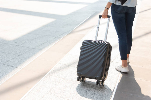 空港で女性とスーツケースのトロリーバッグを閉じます。人々とライフスタイルの概念。旅行とビジネス旅行のテーマ。女性はジーンズを着用しますツアーに行くと一人で世界中を旅女の子 - 写真・画像