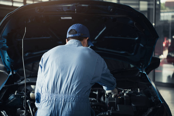 Car mechanic opening car hood for internal checking to maintenance vehicle by customer claim order in auto repair shop garage. Engine repair service. People occupation and job. Automobile technician - 写真・画像