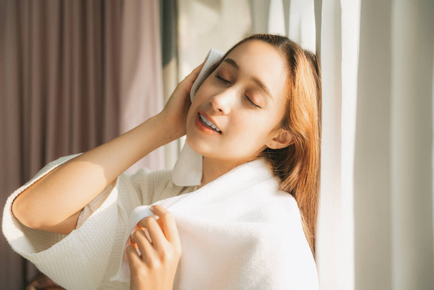 Sexy młoda kobieta w białym szlafroku za pomocą ręcznika czyste włosy wytrzeć po wyjściu z łazienki. W środku. Mieszkanie. - Zdjęcie, obraz