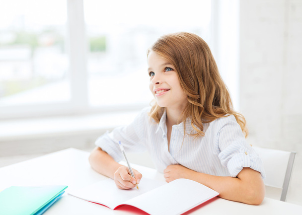 Student girl writing in notebook at school - Фото, зображення