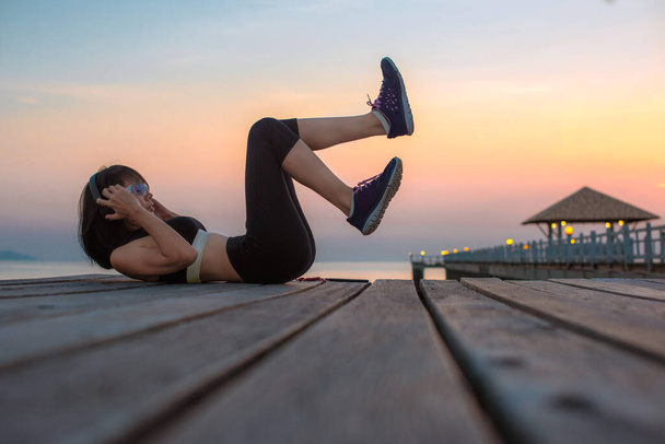 young woman sport exercise practice on wooden bridge in the sea at sunset, relax and comfortable in place - Photo, Image