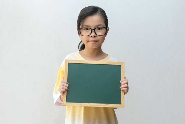 Asyalı kız elinde boş tahta tutuyor. Eğitim kavramı - Fotoğraf, Görsel