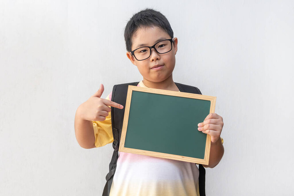 空のボードを持っているアジアの少年学生。学校に戻る。教育の概念 - 写真・画像