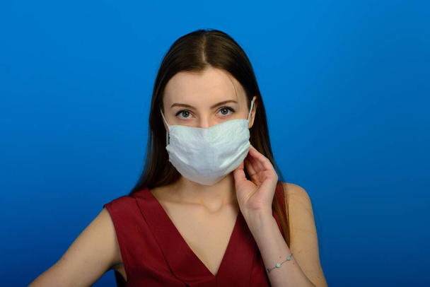 Дівчина в захисній медичній масці і синіх рукавичках на синьому фоні. крупним планом портрет жінки в прозорій масці. спосіб захисту від коронавірусу. Ковід-2019, Пандемія 2020
 - Фото, зображення