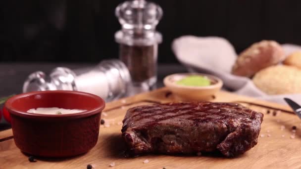 masový steak na dřevěné desce s omáčkou a kořením - Záběry, video