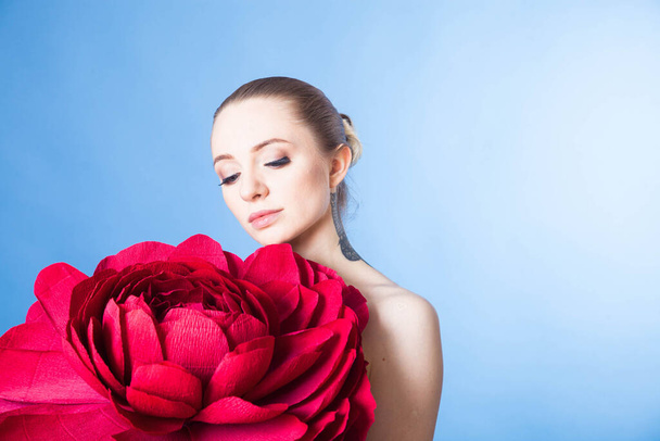 beautiful girl with healthy skin relaxes after a Spa treatment with a red flower - Photo, image
