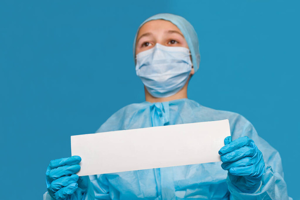Jovem médico mostrando papel branco em branco para escrever qualquer informação
. - Foto, Imagem