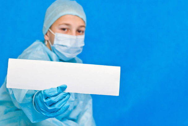 Mladý lékař ukazuje bílý prázdný papír pro psaní jakýchkoliv informací. - Fotografie, Obrázek