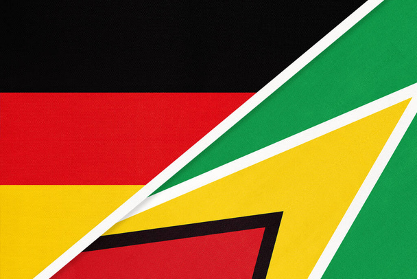 Bondsrepubliek Duitsland tegen Guyana, symbool van twee nationale vlaggen uit textiel. Relatie, partnerschap en kampioenschap tussen Europese en Amerikaanse landen. - Foto, afbeelding