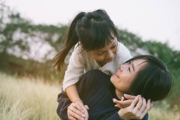 Madre e hija abrazándose y acostándose al aire libre con smillig, Concepto de te amo mamá
 - Foto, Imagen