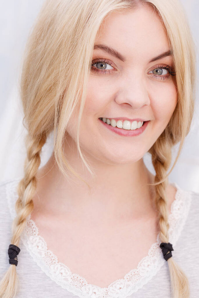 Happy funny woman having long blonde hair in two braided hairstyle. Haircare concept. - Fotoğraf, Görsel