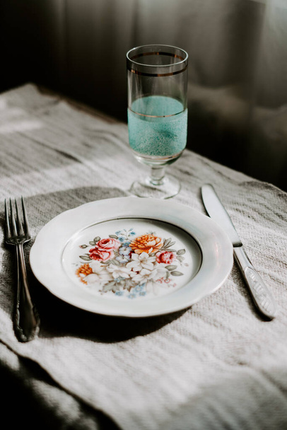 table setting for  breakfast. there are plate, knife, fork and water glass on the couvert.  - Photo, Image