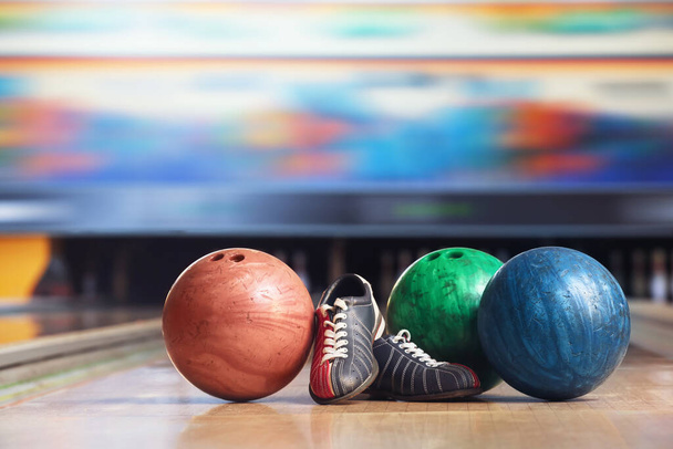 Schoenen en ballen op de vloer in bowlingclub - Foto, afbeelding