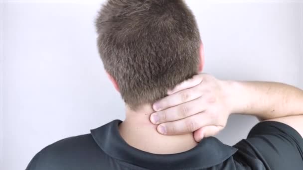 Un hombre sufre de dolor en el cuello, masajea la columna cervical con la mano. Osteocondrosis, hernia o lesión nerviosa debida a trabajo sedentario o estrés físico
 - Metraje, vídeo