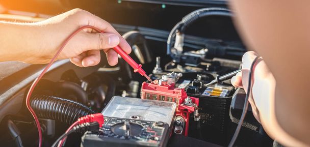Mechanic repairman checking engine automotive in auto repair service and using digital multimeter testing battery to measure various values and analyze, Service and Maintenance car battery check. - Φωτογραφία, εικόνα