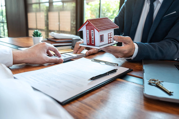 Агент по недвижимости предоставляет ипотечный кредит и отправляет ключи клиенту после подписания контракта на покупку дома с утвержденной формой заявки на приобретение недвижимости, концепция Страхового дома. - Фото, изображение