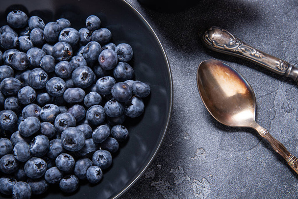 Fresh blueberries in black ceramic bowl - Φωτογραφία, εικόνα