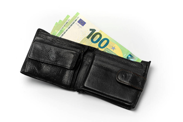 zwart lederen mannenportemonnee en diverse bankbiljetten van 100 euro op een witte achtergrond - Foto, afbeelding