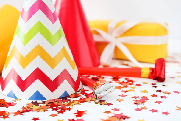Party hats, gift and decor on white background - Photo, Image