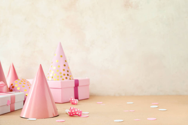Party hats and gift boxes on light background - Photo, Image