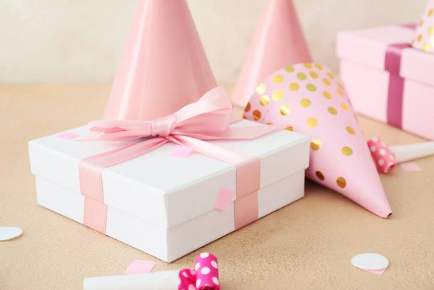 Party hats and gift boxes on light background - Fotoğraf, Görsel