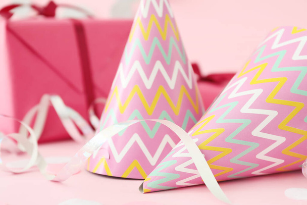 Party hats, gift and decor on color background - Photo, Image
