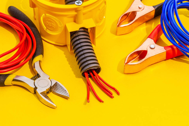Części zamienne, narzędzia i przewody do wymiany lub naprawy sprzętu elektrycznego na żółtym tle - Zdjęcie, obraz