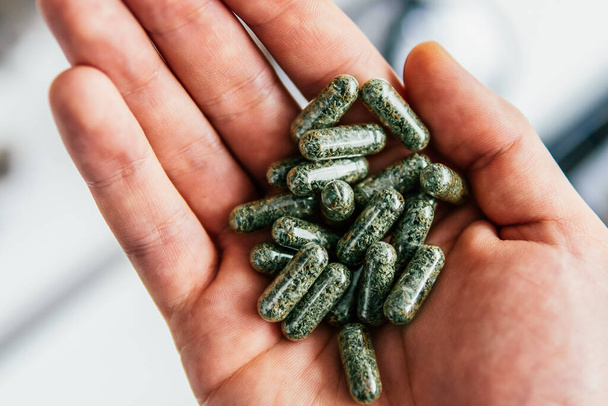 Pills with cannabis in the hands. close up, product of hemp, medical marijuana . THC CBD cannabis. The concept of taking hemp in food. - Photo, Image