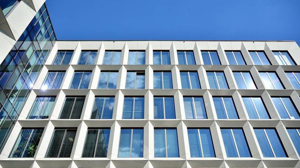 Moderni toimistorakennus ikkunat pystysuorat linjat ja heijastus. Rakennus heijastaa taivasta pilvillä ja luoda surrealistinen näkymä
. - Valokuva, kuva