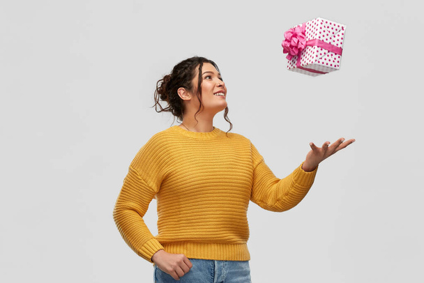 smiling young woman throwing gift box - Foto, Bild