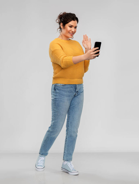 happy young woman having video call on smartphone - Photo, image