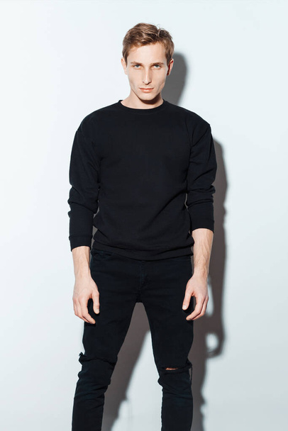 Handsome Fashion Man In Black Sweatshirt Posing On White Background. Model Test. Mock-up Sweatshirt  - Photo, image