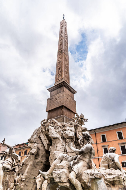 Four Rivers Fountain, Italian Fontana dei Quattro Fiumi, with obelisk and St Agnes Church on background. Piazza Navona square, Rome, Italy - Фото, изображение