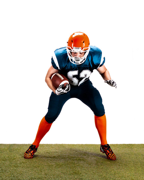 American football player with ball in action on the grass isolated on the white - Foto, afbeelding