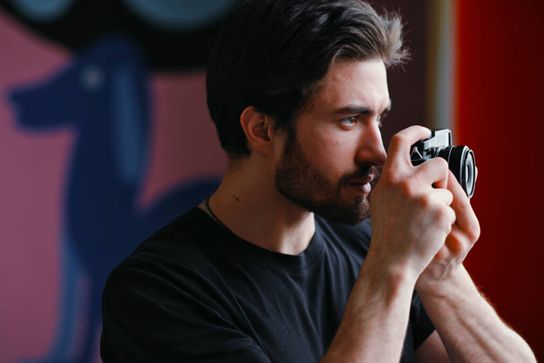 Male photographer uses a mirrorless camera to take a picture. - Fotoğraf, Görsel