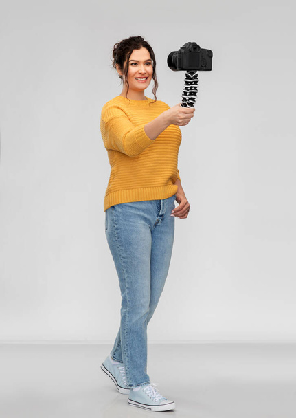 donna blogger sorridente con videocamera registrazione video
 - Foto, immagini