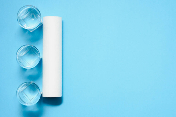 Water filters. Carbon cartridges and glasses on a blue background. Household filtration system. - Foto, immagini
