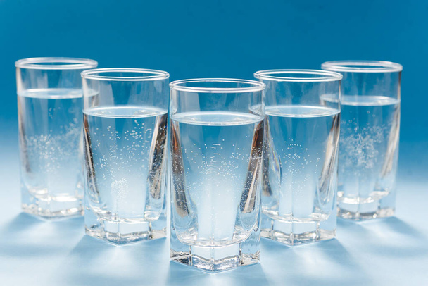 Glasses of water on blue. Close up. Copy space. Water balance for healthy and detox. - Fotoğraf, Görsel