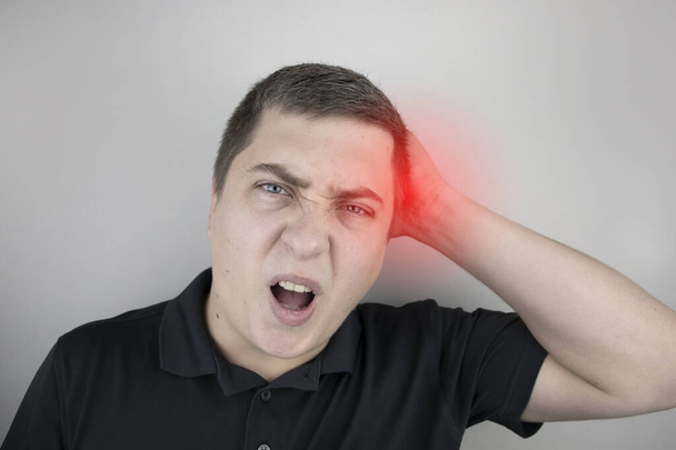 Ein Mann leidet unter Schmerzen im Hinterkopf. Anzeichen für zervikale Osteochondrose, Spondylose, Myositis oder Bluthochdruck. Das Konzept der akuten Schmerzen in verschiedenen Teilen des Körpers - Foto, Bild