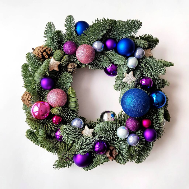 クリスマスの花輪は白い背景にある。装飾要素は、コーン、ガラスボール、クリスマスの星です。花輪の基礎はトウヒの枝です。これは青とピンクのボールが入った丸い天然のリースです - 写真・画像