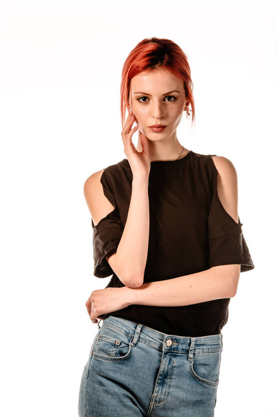 Studio body shot trendikäs nuori punapää nainen yllään moderni tyyli housut ja musta t-paita
 - Valokuva, kuva