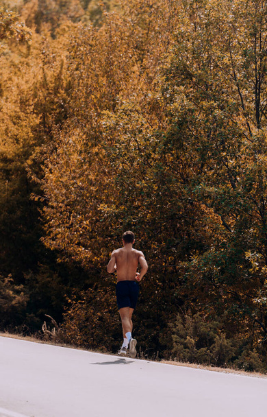 Sport és fitness futó férfi fut közúti képzés maraton futás csinál nagy intenzitású intervallum edzés sprint edzés szabadban ősszel - Fotó, kép