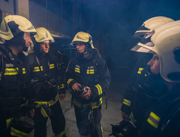 Gruppe von Feuerwehrleuten in der Feuerwehr organisiert Aktionsplan für sichere Ausführung - Foto, Bild