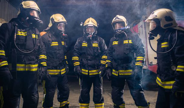 Portrait of group of firefighters in the middle of the smoke of the fire extinguisher - Photo, Image