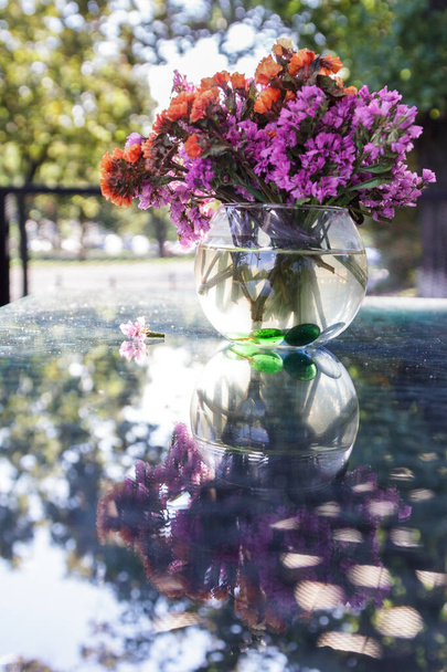 Bukiet suszonych kwiatów w wazonie na szklanym stole - Zdjęcie, obraz