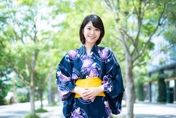 Asiático (Japonês) mulher indo para a cidade vestindo um yukata (traje tradicional japonês
) - Foto, Imagem