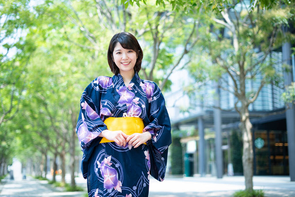 Asian (Japanese) woman going to town wearing a yukata (Japanese traditional costume) - Photo, Image